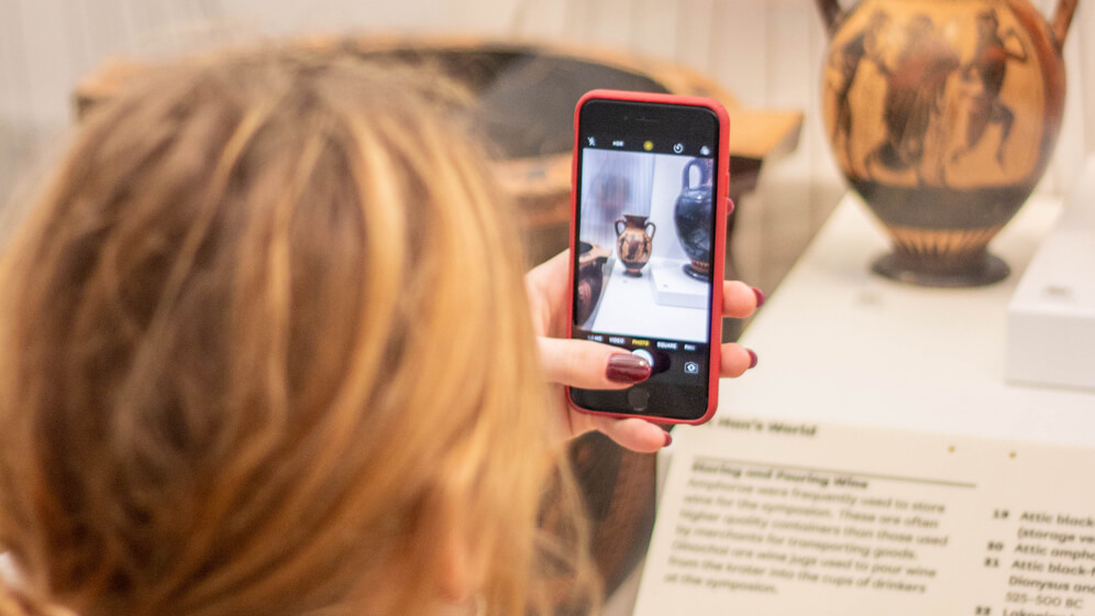 A student photographs an artefact in the Great North Museum